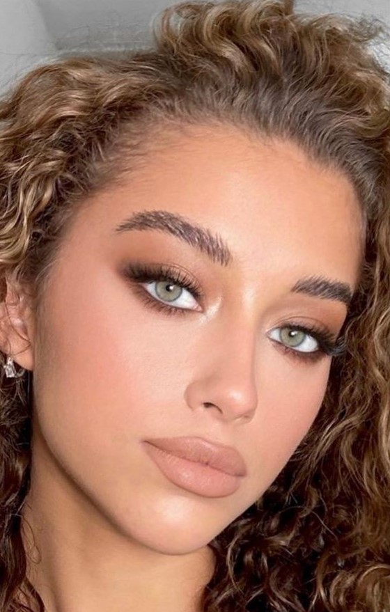 a cool makeup with a nude lip, brownish smokeys, accented eyes with long eyelashes and some blush and highlighter