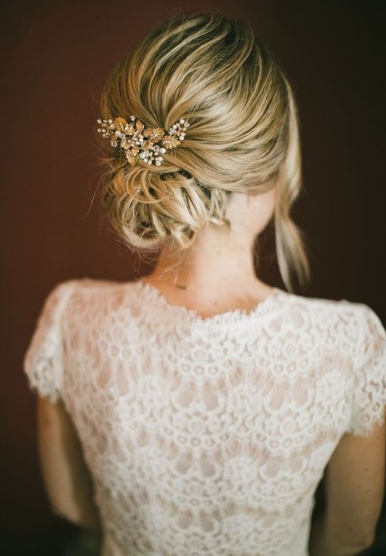 a messy low bun with a bump and a bead and rhinestone hairpiece plus some locks down