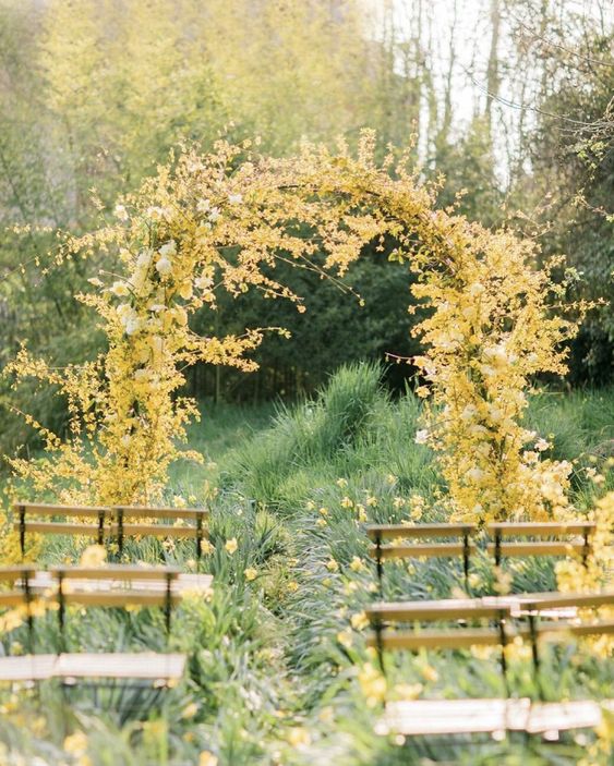 a fantastic yellow wedding arch covered with yellow blooms and blooming branches is a gorgeous idea for summer and fall