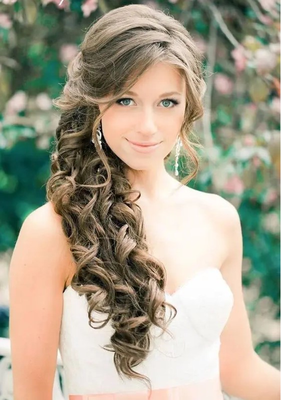 a gorgeous side-swept ponytail with curls and face-framing locks plus a volume on top for a bride with long hair