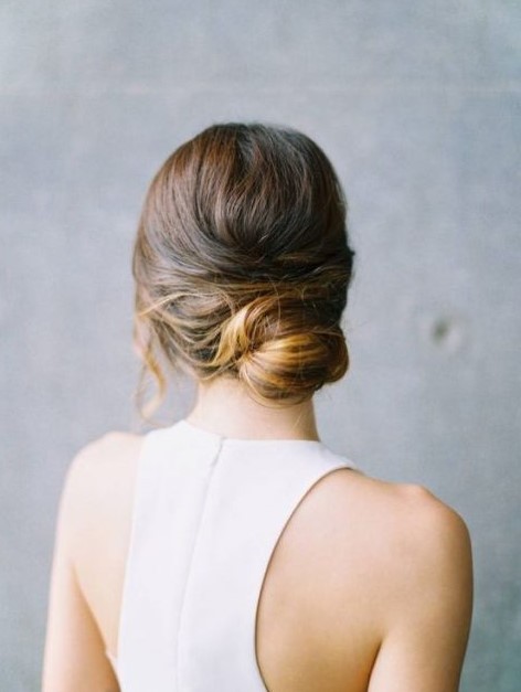 a messy low bun with twists and some hair down is great for a modern bride