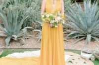 11 a yellow A-line wedding dress with a draped bodice and a plunging neckline, a skirt with a long train
