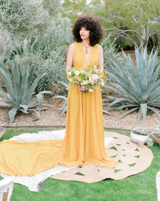 a yellow A-line wedding dress with a draped bodice and a plunging neckline, a skirt with a long train
