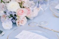 12 a beautiful pastel wedding tablescape with a blue tablecloth, pink, blue and white florals and clear plates with a gold rim