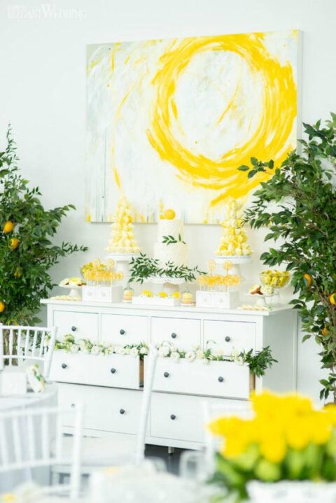 a wedding sweets bar with citrus lollipops, a textural cake topped with a lemon and yellow desserts with citrus flavors