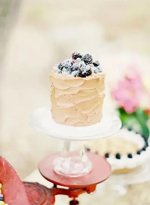 a neutral textural buttercream wedding cake topped with sugared berries is a fantastic idea for a summer wedding, it looks delicious