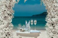 16 a breathtaking white wedding arch completely covered with blooms plus an ocean view are a bold combo for a ceremony