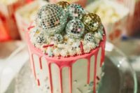 16 a party-themed wedding cake with pink drip, sparkles, beads and disco balls on top is a very bright idea
