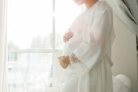 17 a pregnant bride wearing white pajamas with a lace edge and a matching robe over it
