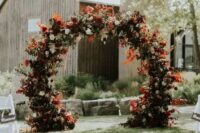 18 a fantastic round fall wedding arch with blush, burgundy and red blooms, greenery and colorful fall leaves and foliage is amazing