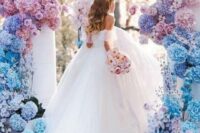 19 a jaw-dropping wedding arbor decorated with pink, blue and lilac blooms covering the pillars looks amazing