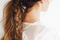 21 a messy textural ponytail with a bump and a side braid with tin flowers in for a boho bride