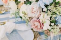 22 a lovely pastel wedding tablescape with a striped tablecloth, a woven placemat, neutral napkins, a gorgeous pastel floral centerpiece