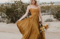 24 a chic mustard spaghetti strap wedding dress with a pleated skirt and a matching wedding bouquet are a great combo for a bride