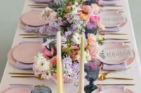 25 a modern pastel wedding tablescape with pink plates and lilac napkins, navy glasses, pastel candles and lovely florals