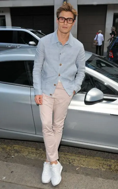 a relaxed summer wedding guest outfit with a white t-shirt, a blue linen shirt, tan pants and white sneakers