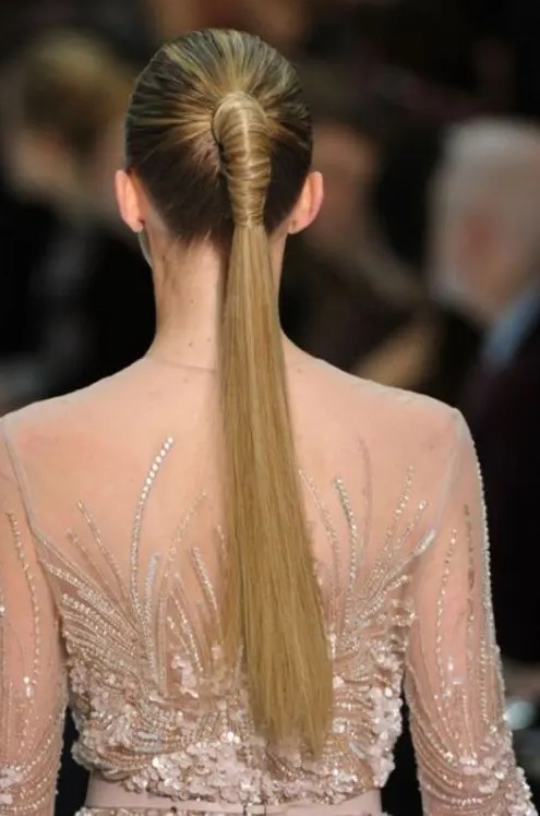 a tall sleek ponytail wrapped with hair, with a sleek top is a stylish idea for a modern or minimalist bride