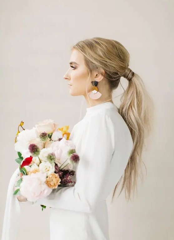 a usual messy ponytail with a texture, a volume on top is ideal for a modern or minimalist bride