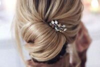 26 an elegant and effortlessly chic chignon with some locks down and a bump on top plus a rhinestone hairpiece