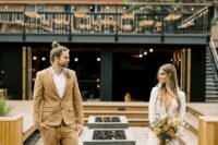 26 an ocher groom’s suit, a white shirt, brown shoes, a dried flower boutonniere and a top knot for a boho fal wedding