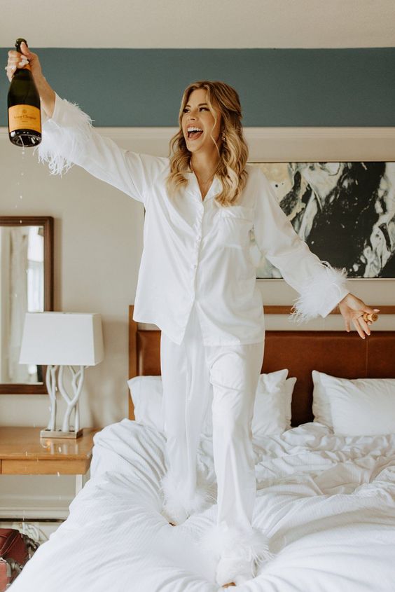 white pajamas with feathers are a cool and lovely idea for a wedding morning, such an outfit always works