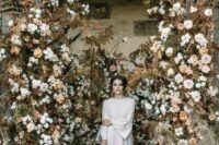 27 a breathtaking fall wedding backdrop of dried leaves, neutral blooms in blush and white is a gorgeous solution to rock