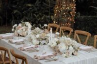 29 a chic and lovely neutral wedding tablescape with neutral linens, dusty pink napkins, white blooms and candles and gold cutlery