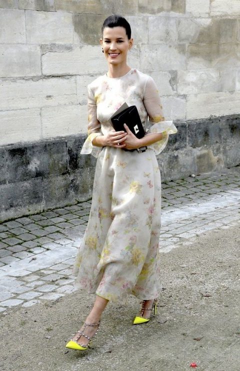 a neutral dress with soft pastel floral prints, a high neckline, ruffled sleeves and neon yellow spiked heels