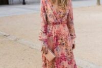 30 a pink floral maxi dress with a deep V-neckline and long sleeves, a blush clutch and a gold headband for a summer wedding