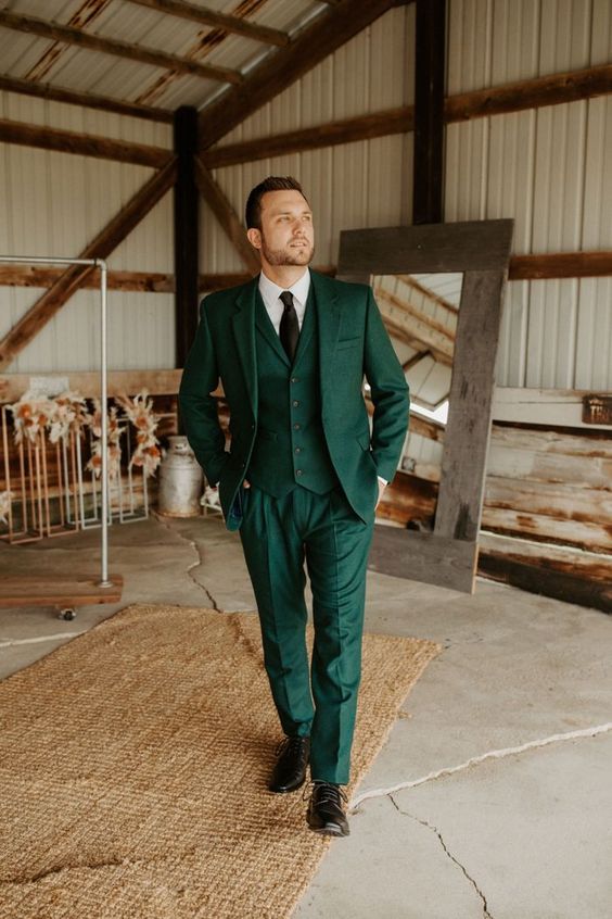 a stylish emerald three piece pantsuit, a white shirt, a black tie and shoes are a cool combo for a boho wedding