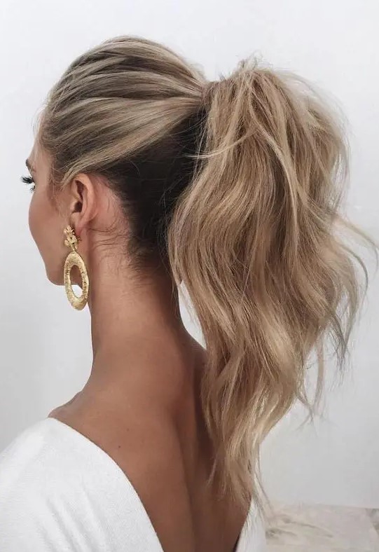 a wavy and voluminous high ponytail looks chic and feminine, besides it's a timeless solution