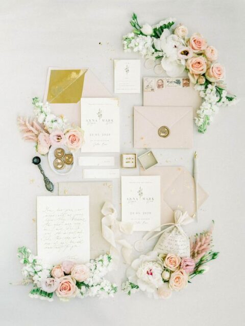 a delicate neutral wedding invitation suite with blush and grey envelopes, chic vintage calligraphy, mustard lining and some blooms around