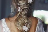 33 a delicate twisted and loose long ponytail with a mesys volume on top, some waves down, white blooms and beads is chic and ethereal