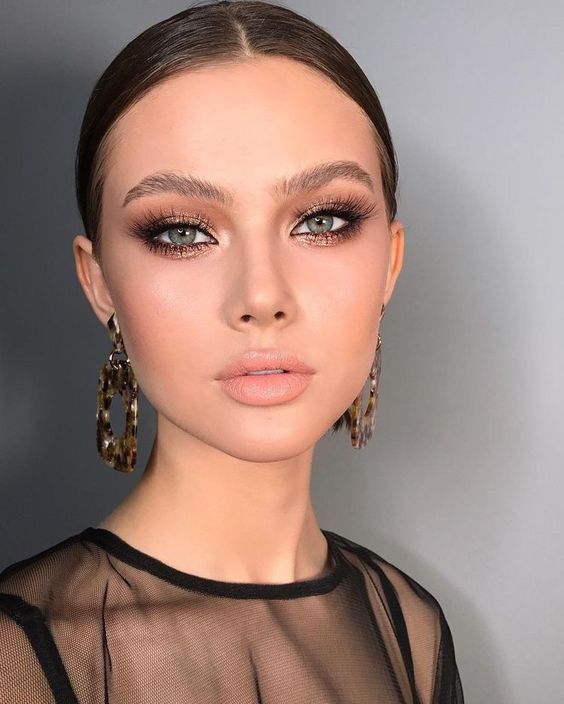a catchy and bold wedding makeup with a glossy nude lip, brownish pink smokeyes and lash extensions and a touch of blush