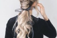 34 a gorgeous low chignon going into a long wavy ponytail and a sheer and etherel grey ribbon with a bow
