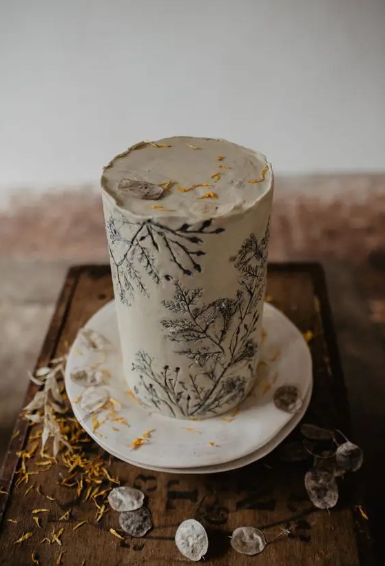 a white buttercream wedding cake with pressed blooms and petals is a lovely and very trendy idea