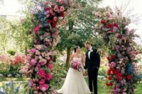 35 a bold wedding altar with light and hot pink, lilac, blue and purple and red blooms plus some greenery is amazing for a jewel-tone wedding