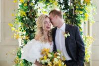 35 a bright wedding arch with much greenery and bold yellow blooms plus a matching wedding bouquet for spring