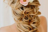 35 a long curly ponytail with a lot of volume and some fresh blooms tucked in is a very refined and chic idea for a bride with long hair