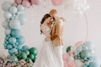 35 a round wedding arch decorated with white and pastel balloons and with pastel blooms and candles at its base