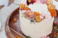 35 a white textural buttercream wedding cake topped with bold dried blooms and thistles is a catchy idea for a summer wedding