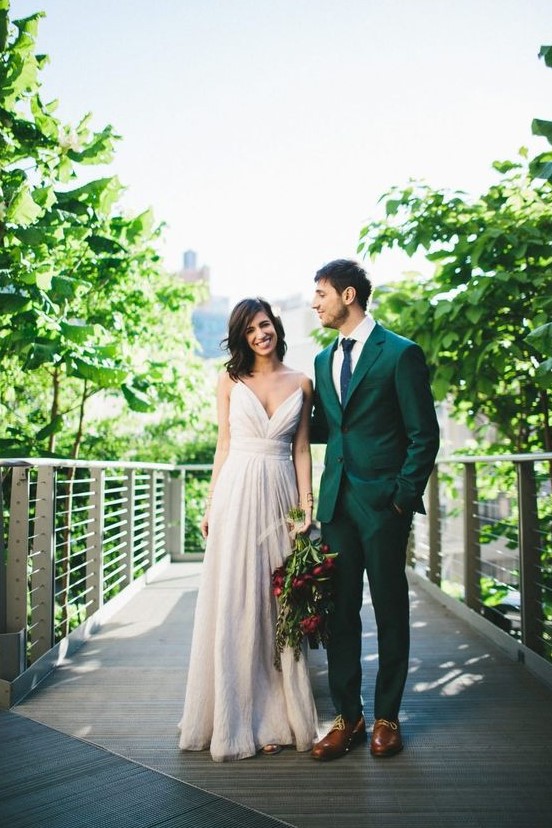 an emerald groom's suit paired with a navy tie, brown shoes and a white shirt for a bold modern look