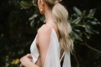 36 a long low textural and wavy ponytail with a sleek top and pearls that accent the hairstyle is a cool idea for a modern bride