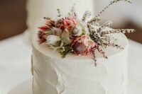 36 a white textural buttercream wedding cake with pink and neutral blooms and twigs for a spring or summer wedding