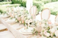 37 a lovely wedding tablescape with greenery, peachy and blush blooms, creamy and gold porcelain, pink glasses and blush candles
