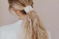 37 a low and messy ponytail wrapped up in pearls is a chic idea for a modern or minimalist bride