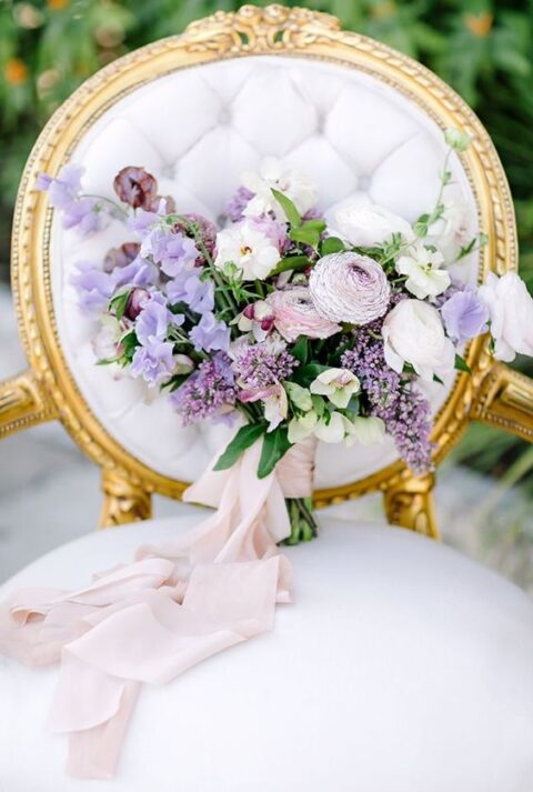 a sophisticated wedding bouquet of lilac, white and blush blooms and greenery plus long blush ribbons is a stylish and chic idea