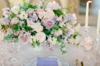 38 a sophisticated wedding tablescape with lilac and neutral blooms, eye-catchily shaped plates, candles and vintage glasses