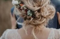38  messy and loose wedding low updo with waves and locks down and with a floral accent – neutral and blush blooms and greenery