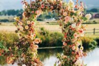 40 a beautiful and bright fall wedding arch of pink, blush and neutral blooms, greenery and bold foliage is a very cool and cheerful idea